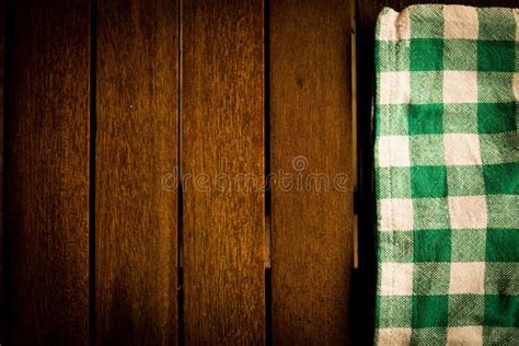 Green And White Checkered Tablecloth On A Wooden Surface Stock Photo