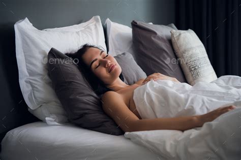 hotel, travel and happiness concept - beautiful woman sleeping in bed Stock Photo by romankosolapov