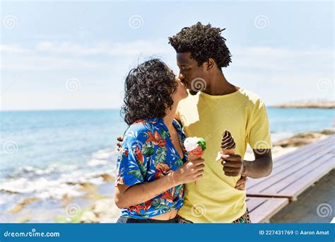 Young Beautiful Couple Smiling Happy Eating Ice Cream At The Beach