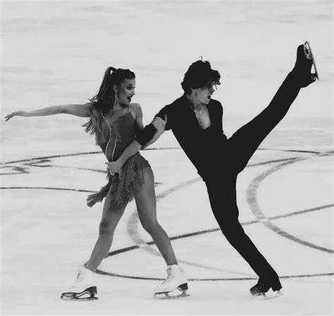 Two People Skating On An Ice Rink With One Holding The Other S Leg Up