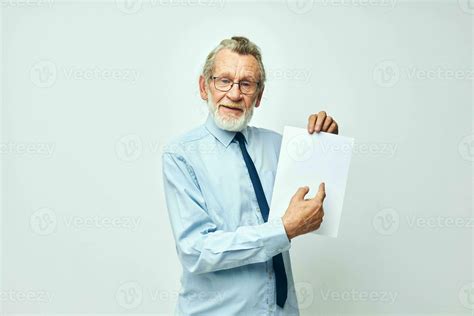 Senior Grey Haired Man Holding Documents With A Sheet Of Paper Light