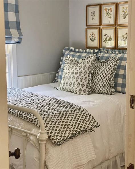 A Bed With Blue And White Comforters In A Bedroom Next To Pictures On