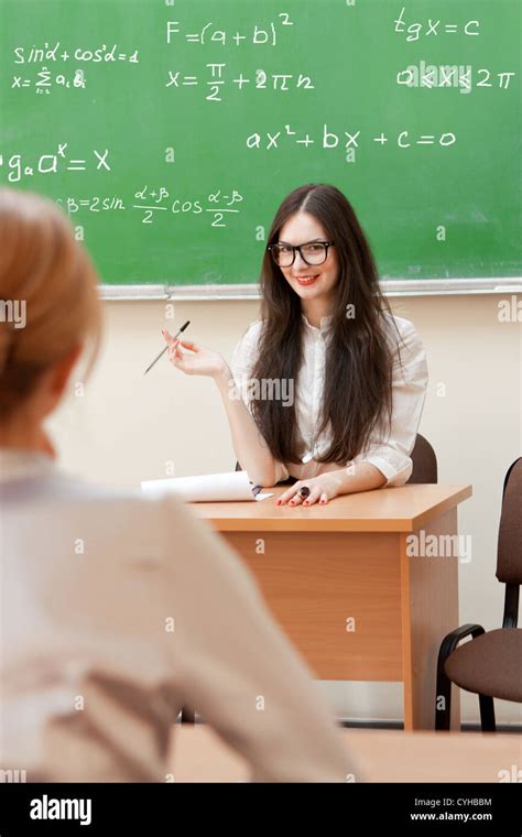 The teacher in the classroom on blackboard background Stock Photo - Alamy