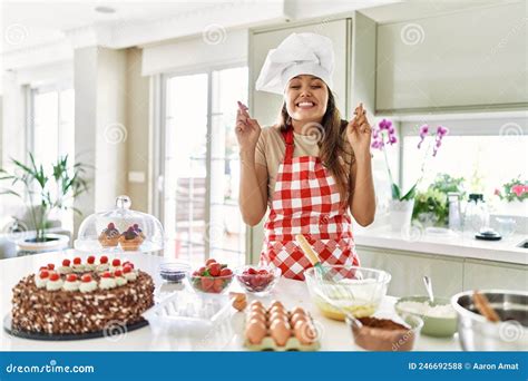 Beautiful Young Brunette Pastry Chef Woman Cooking Pastries At The Kitchen Gesturing Finger