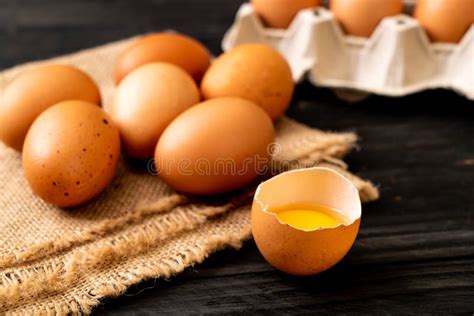 Huevos De Brown Con Uno Quebrado Y La Yema De Huevo Foto De Archivo