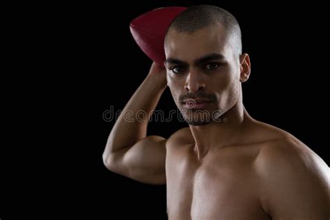 Muscular American Football Player Holding Football And Head Gear In His