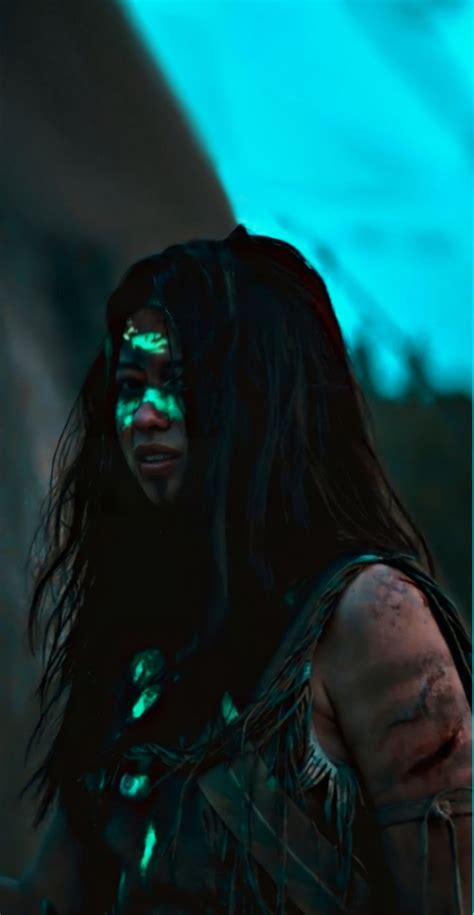 A Man With Long Black Hair And Glowing Green Eyes Standing In Front Of