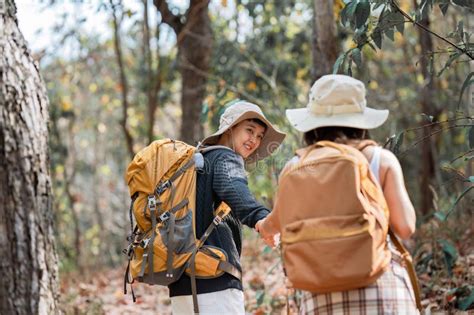 Happy Lgbt Lesbian Couple Travelers Hiking With Backpacks In Forest