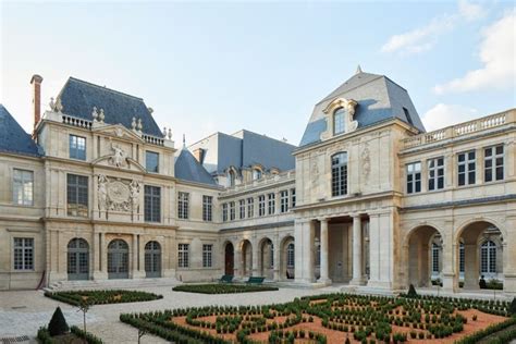 A Large Building With A Garden In Front Of It