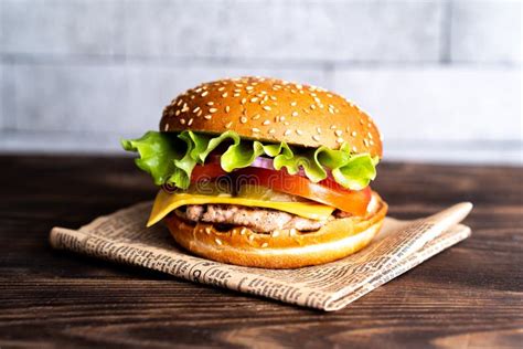 Hamburger With Cutlet Tomato And Cheese On A Dark Wooden Table And