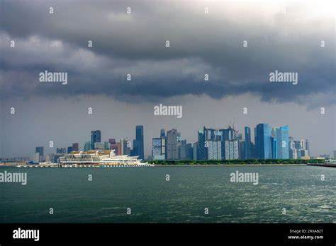View From Straits Of Singapore Of The Singapore Skyline Under Stormy