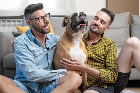 Feliz Pareja Gay Sentada En El Suelo Y Jugando Con El Perro En Casa Foto Premium