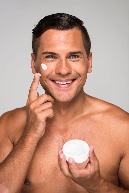 Primer Plano Sonriente Hombre Tenencia Crema Facial Foto Gratis