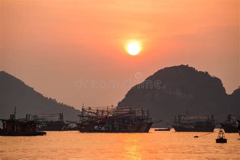 Asian Fishing Boats At Sunset On A Background Of Mountains Stock Photo