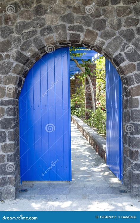 Porta De Madeira Azul Velha Do Jardim Na Parede De Pedra Imagem De