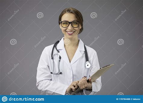 Smart Woman Doctor With Clipboard Broadly Smiles Friendly Looks At