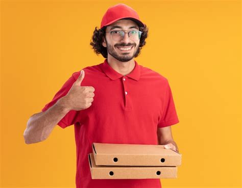 Repartidor Cauc Sico Joven Sonriente En Uniforme Rojo Y Gorra Con Gafas