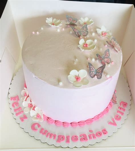 There Is A Cake In The Box With Butterflies On It And Pink Ribbon