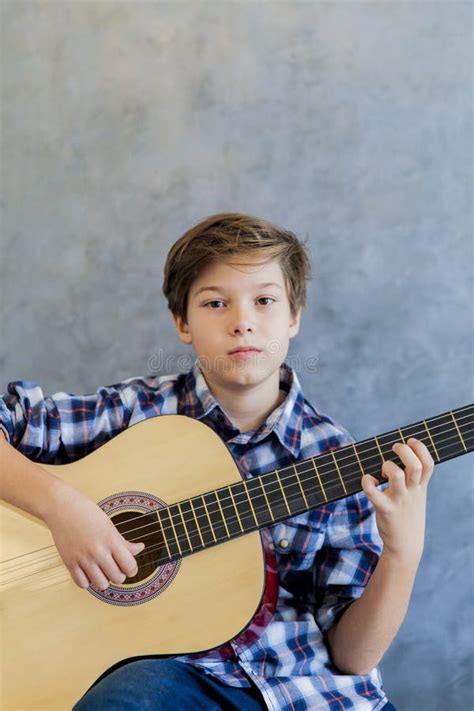 Adolescente Que Toca La Guitarra Acústica En Cama Imagen de archivo