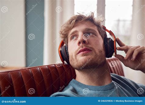 Man Wearing Wireless Headphones Listening To Music Relaxing On Armchair