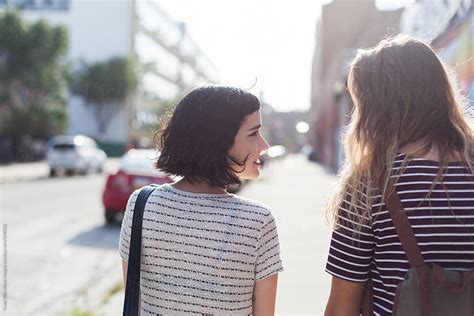 Two Friends Walking In The Street By Stocksy Contributor Vero