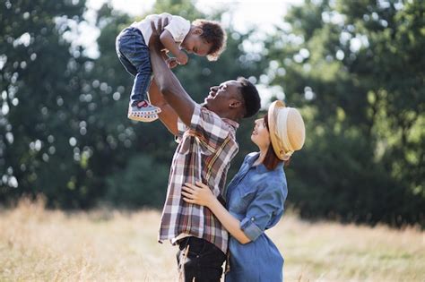 Feliz Familia De Raza Mixta De Tres Jugando En El Campo Foto Premium