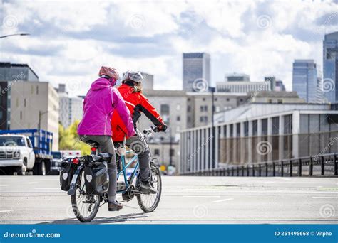 Two Amateur Cyclists Wearing Colorful Jackets Are Cycling On A Tandem