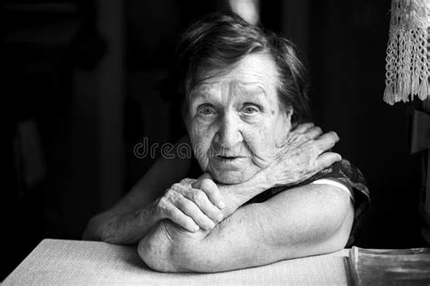 Portrait Of Old Woman Sits In Her House Black And White Photo Stock