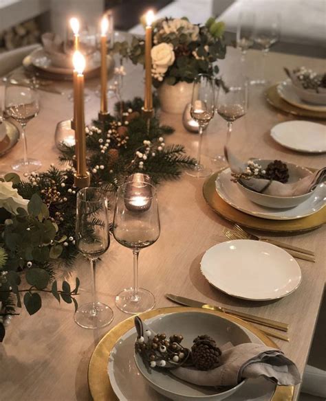 The Table Is Set With Plates Silverware And Candles