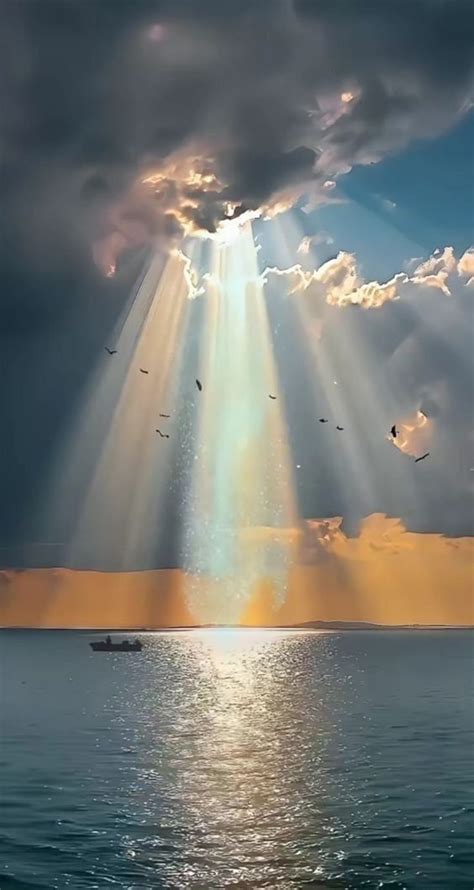 The Sun Shining Through Clouds Over Water With Birds Flying Above It