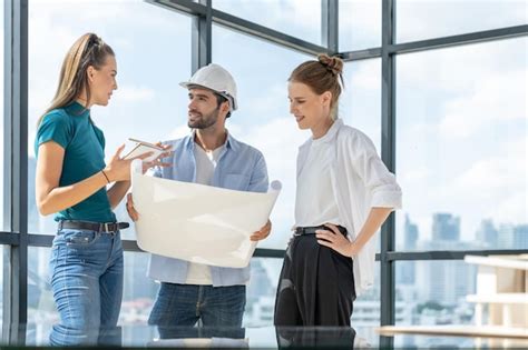 Grupo De Arquitectos E Ingenieros Mirando El Plan Del Proyecto Mientras