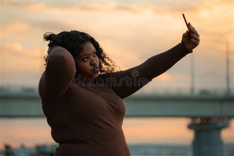 Curly Pretty Interracial Woman In Elegant Brown Dress Taking Selfie By