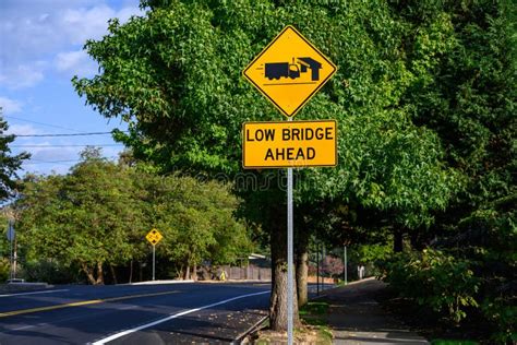 Yellow Road Sign Low Bridge Ahead With A Truck And Bridge Symbol