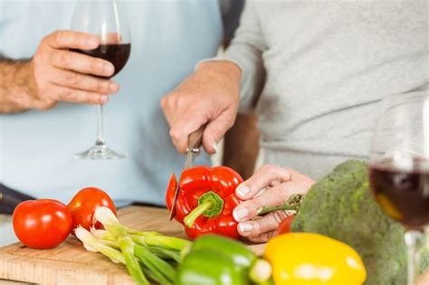 Premium Photo Mature Couple Having Red Wine While Making Dinner