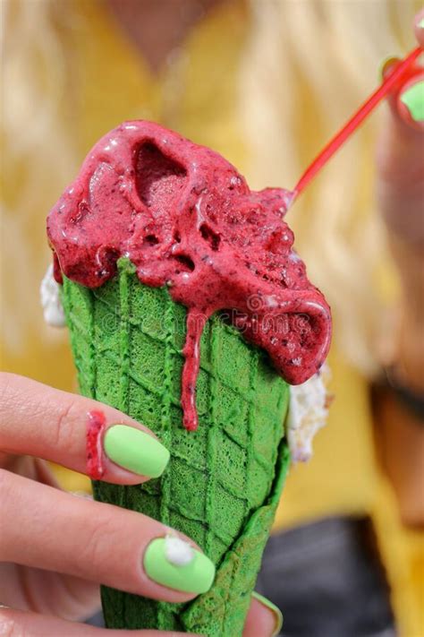 Hand With Green Nails Is Holding A Melting Fruit Ice Cream Cone With