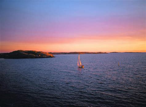 帆船无人横图室外白天正面旅游度假海浪海洋石头美景日落船瑞典欧洲石子景观浪花水平线晚霞霞光落日辽阔