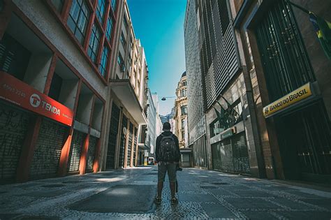 Royalty Free Photo Man Standing Between Tall Buildings Under Calm Sky