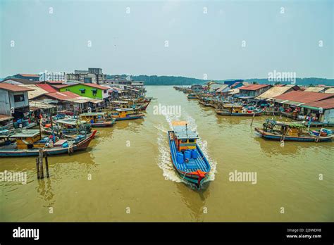 A Fishing Boat Moving Through The River And Passing Through A Row Of