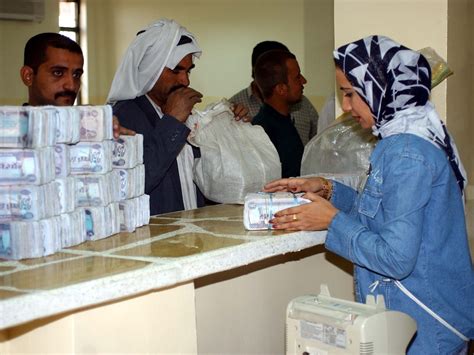 A Bank Worker Exchanges Old Currency For New Iraqi Dinars At The