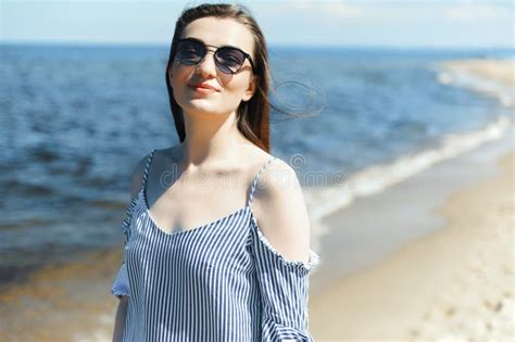 Portrait Of A Happy Smiling Brunette Woman Standing On Ocean Beach And