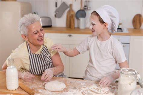 Familia feliz en la cocina abuela y nieta niño cocinan juntos en la