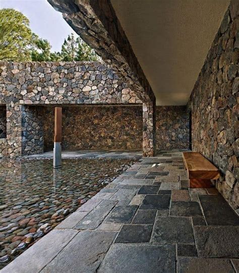 An Outdoor Area With Stone Walls And Benches