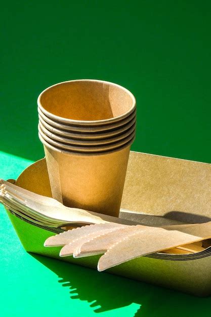 Premium Photo Wooden Forks And Paper Cups With Plates On Green