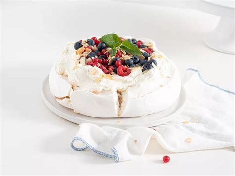 A Cake With Berries And Nuts On It Sitting On A Plate Next To A Towel