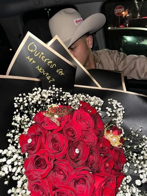 A Man Sitting In The Back Of A Car With Flowers And Cards On His Lap