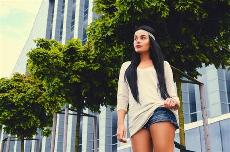 Free Photo Sexy Brunette Female In Denim Shorts And In A White Jacket Over Modern Building