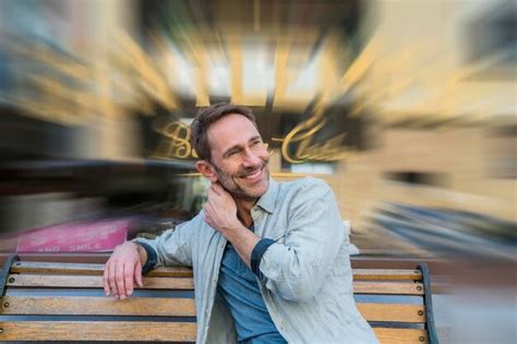 Premium Photo Portrait Of Smiling Mature Man Sitting On Wooden Bench