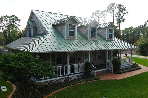 house with green metal roof - catadoptionsbylisa