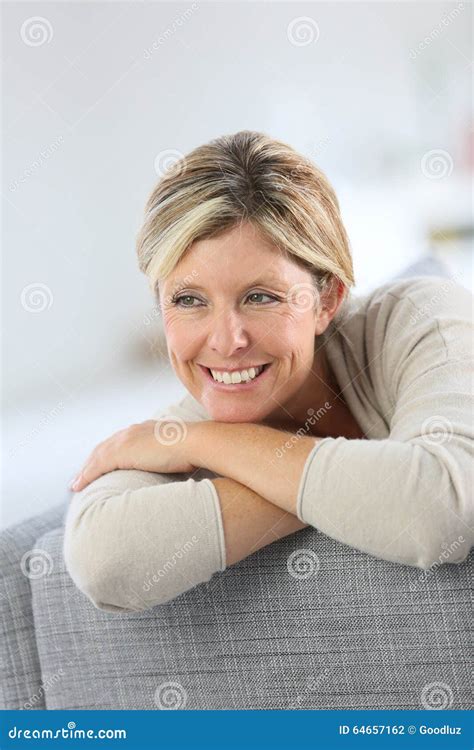 Femme Blonde De Sourire S Asseyant Sur Le Sofa Photo Stock Image Du Gens Assez