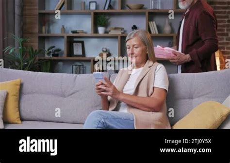 Caring Old Husband Giving Romantic Birthday Present To Excited Mature Wife Loving Older Man